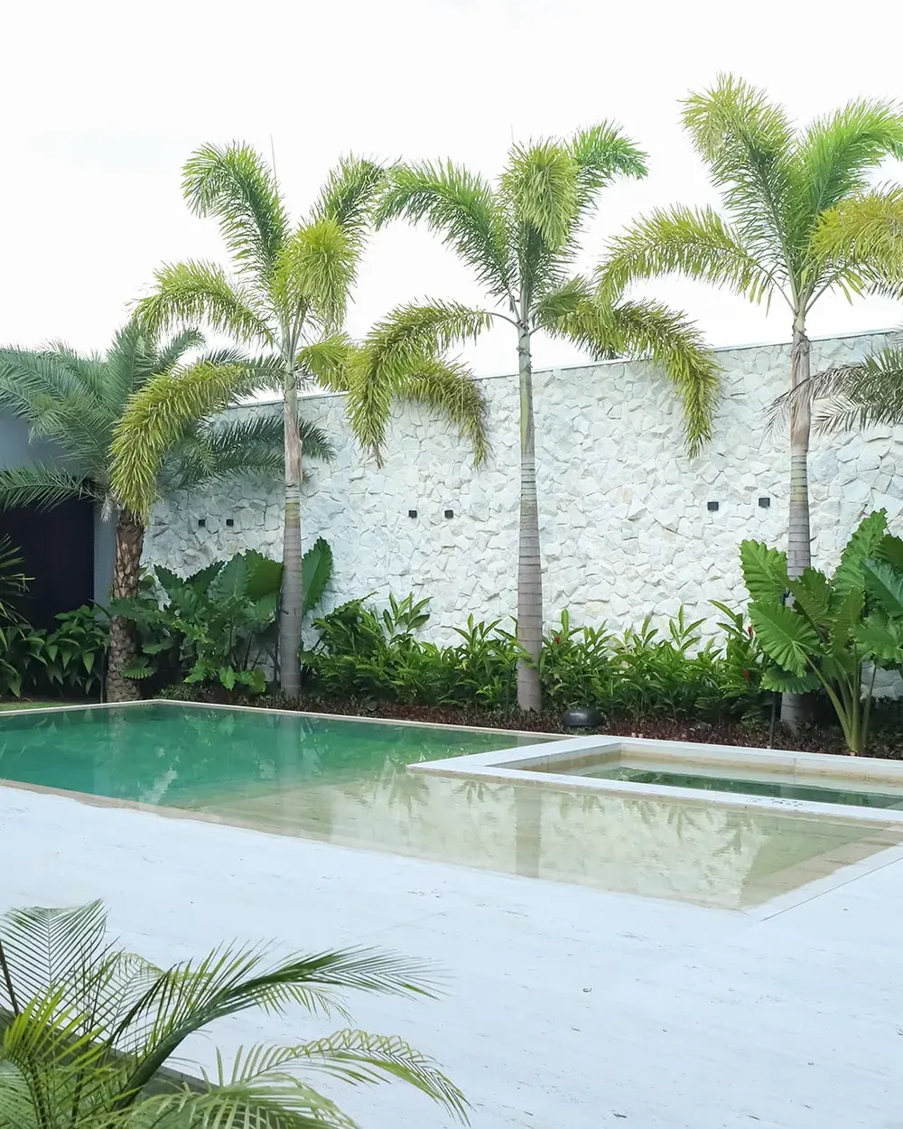 Piscina com deck em pedra natural e paisagismo