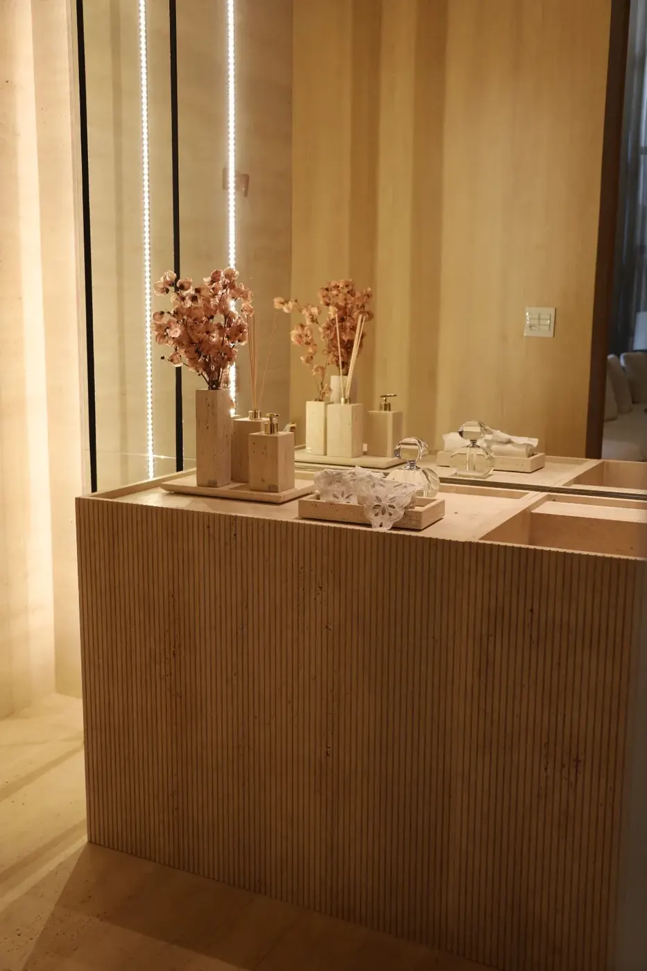 Bancada de lavabo em travertino com acessórios de decoração